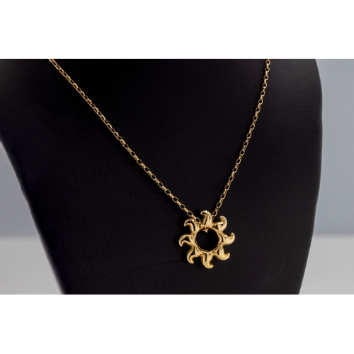 1050 - A 9ct yellow gold sun pendant suspended on a 9ct gold chain, length 47cm.