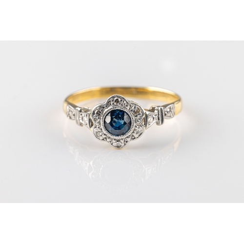 1065 - A sapphire and diamond ring in 18ct yellow gold and platinum, of foliate design centred on a bezel-s... 