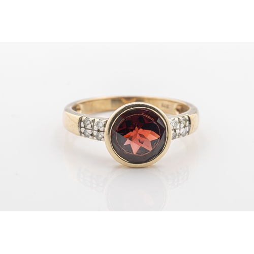 1069 - A paste and diamond ring in 9ct yellow gold with a bezel-set mixed round shaped red paste stone and ... 