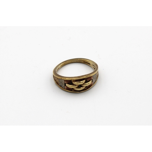 1078 - A three colour 9ct gold ring having ornate three colour gold panels centred by ring effect decoratio... 