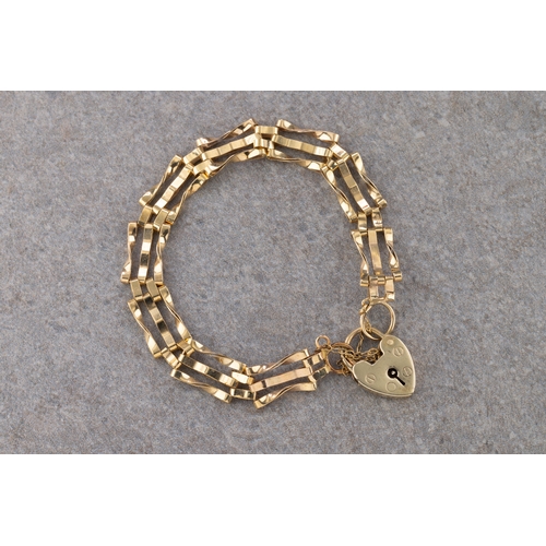 1095 - A 9ct yellow gold padlock and gate chain bracelet with safety chain, marked 9ct on padlock and ring.