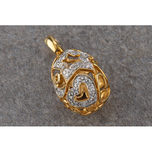 1163 - A 9ct yellow gold and diamond egg charm pendent of pierced star & heart design.