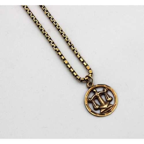 1202 - A 9ct yellow gold 'Scales of Justice' pendent and chain 38cm. long.