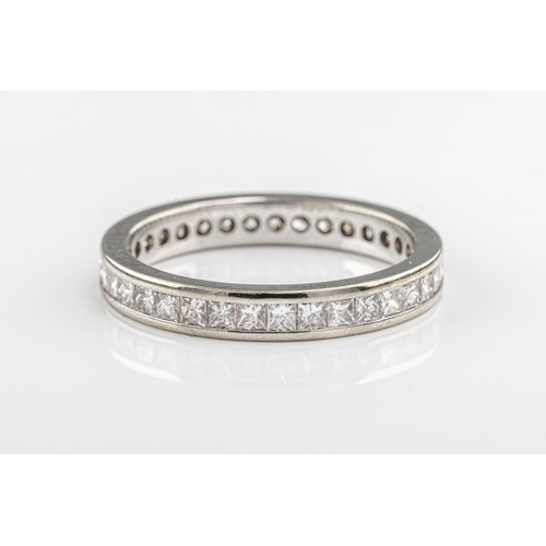 1263 - A full diamond eternity ring in 18ct white gold, channel-set with princess-cut diamonds, ring size L... 