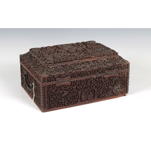 1369 - A 19th century Anglo-Indian heavily carved sandalwood travelling box of rectangular casket form, hav... 