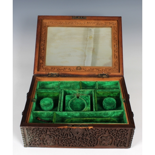 1369 - A 19th century Anglo-Indian heavily carved sandalwood travelling box of rectangular casket form, hav... 