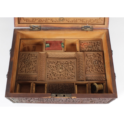 1369 - A 19th century Anglo-Indian heavily carved sandalwood travelling box of rectangular casket form, hav... 