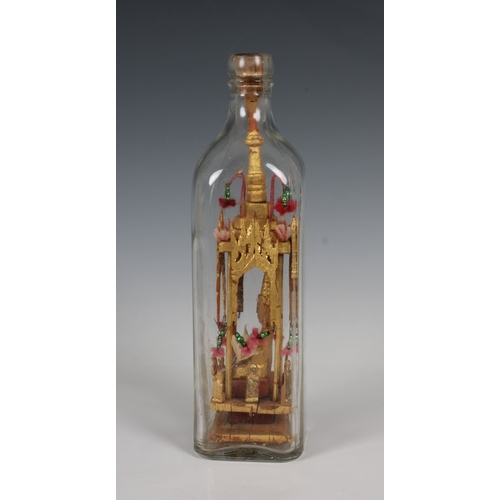 1373 - A 20th century folk/tramp art Buddha in a bottle the gilt wood sculpture housed in a clear Walker's ... 