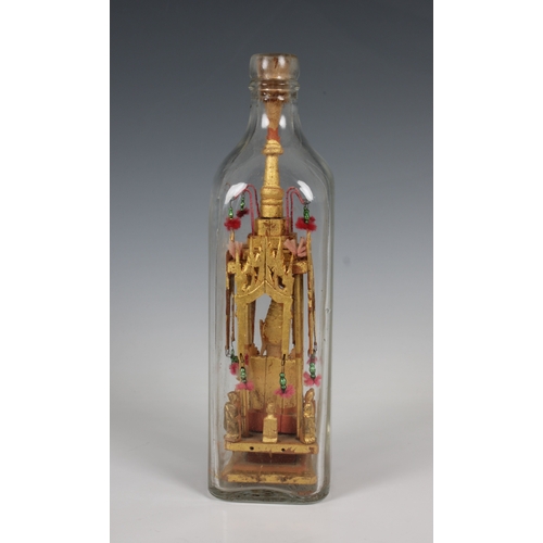 1373 - A 20th century folk/tramp art Buddha in a bottle the gilt wood sculpture housed in a clear Walker's ... 