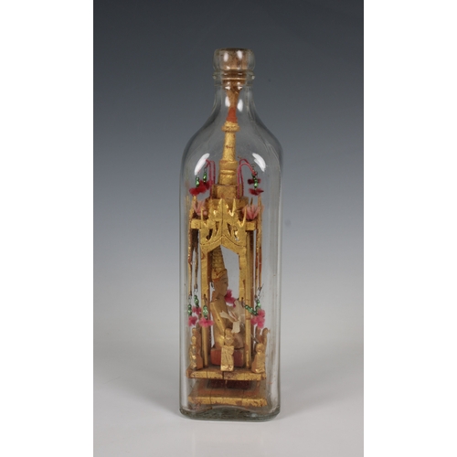 1373 - A 20th century folk/tramp art Buddha in a bottle the gilt wood sculpture housed in a clear Walker's ... 