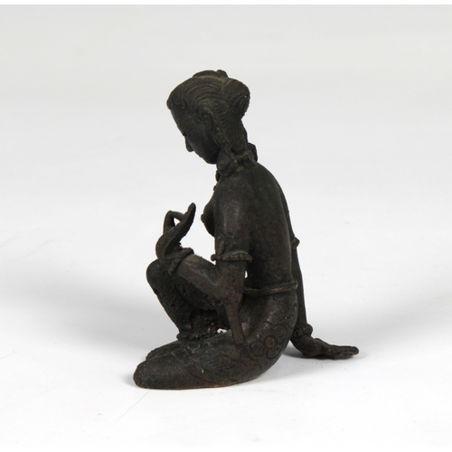 1375 - A miniature seated bronze of a Hindu Goddess 7cm. high.