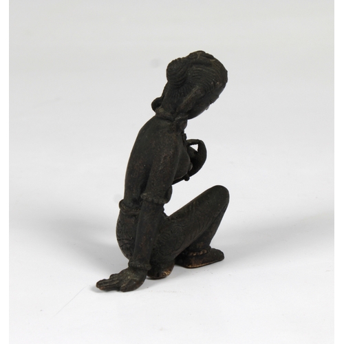 1375 - A miniature seated bronze of a Hindu Goddess 7cm. high.