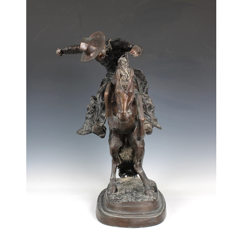 1400 - A large bronze figure of a cowboy on horseback, in the manner of Frederick Remington modelled as 'Th... 