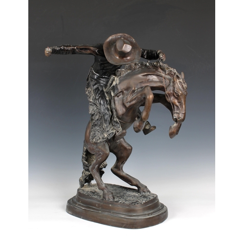 1400 - A large bronze figure of a cowboy on horseback, in the manner of Frederick Remington modelled as 'Th... 