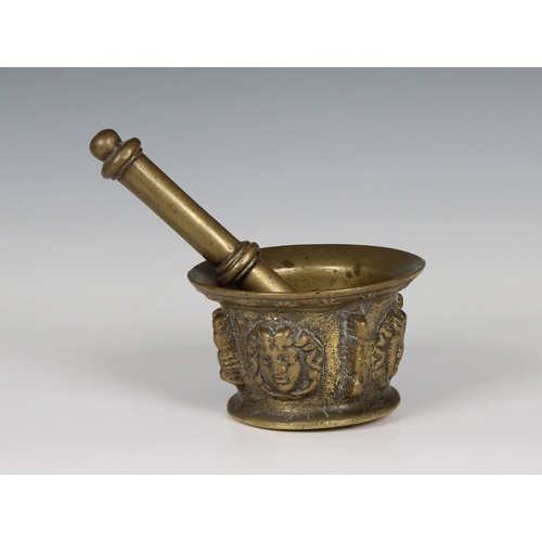 1448 - A 17th century figural brass apothecary pestle and mortar the body decorated with four classical mas... 