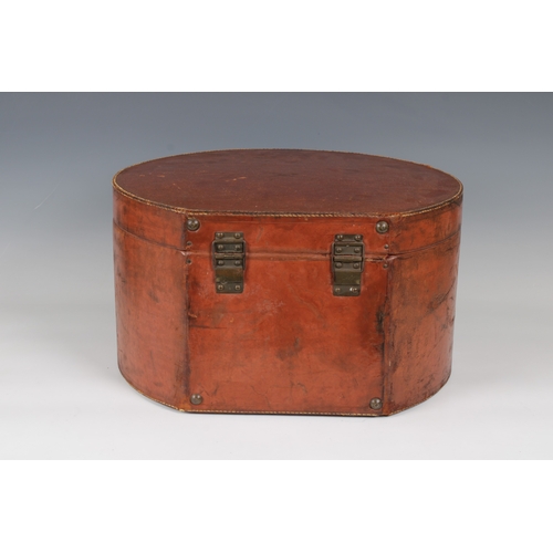 1450 - A large leather hat box or circular form with lock and carry handle, the hinged cover opening to rev... 