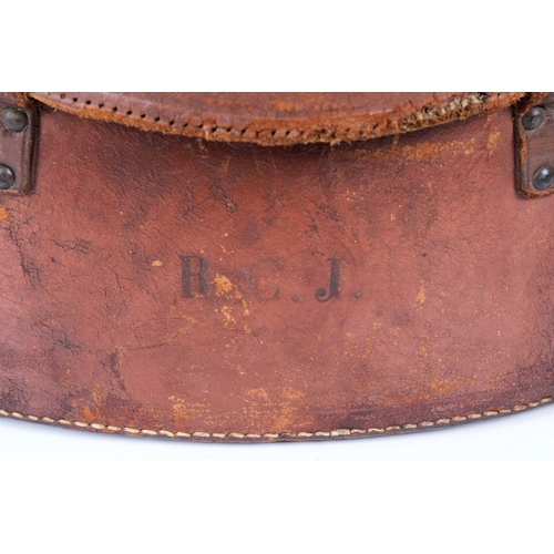 1450 - A large leather hat box or circular form with lock and carry handle, the hinged cover opening to rev... 