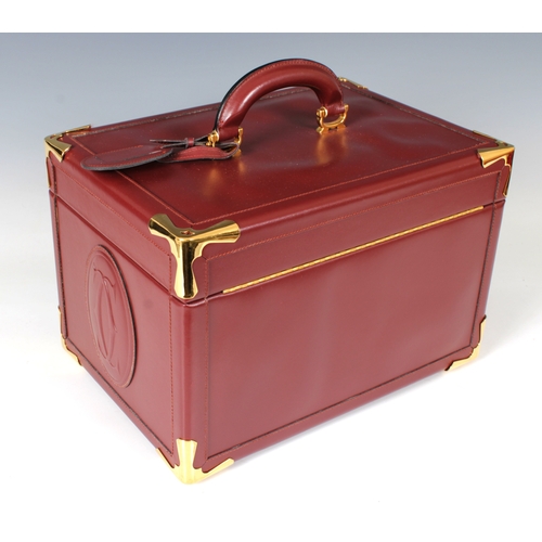 1495 - A Cartier burgundy leather vanity case with gilt metal fittings, combination locks, vanity mirror an... 