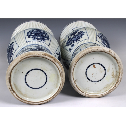 693 - A pair of early 20th century Chinese blue and white porcelain vases zun form, with incised fluted de... 