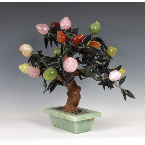 728 - An Oriental carved hardstone tree centrepiece bearing various coloured fruit, 42cm. high.