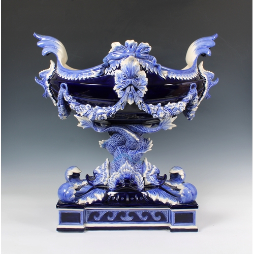 33 - An impressive ceramic blue glazed jardiniere of navette form, having dolphin head lugs and supported... 