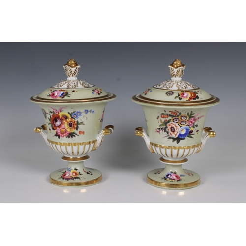 39 - A pair of porcelain campana urn form sauce tureens and covers having hand painted flower sprays on p... 