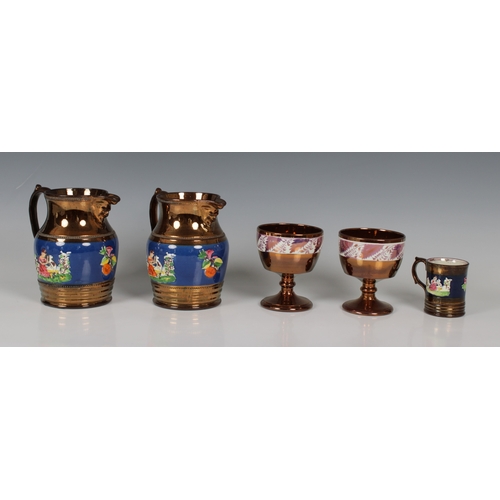 64 - A pair of English copper lustre jugs circa 1840, the central blue band sprig moulded with figures in... 