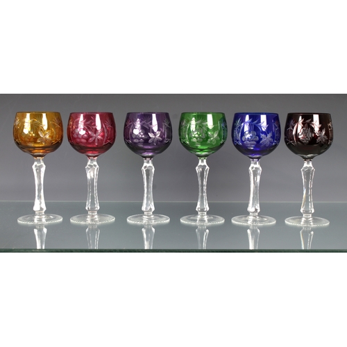 130 - A set of six Bohemian cut glass and coloured overlay wine glasses on cut tapering and faceted stems ... 