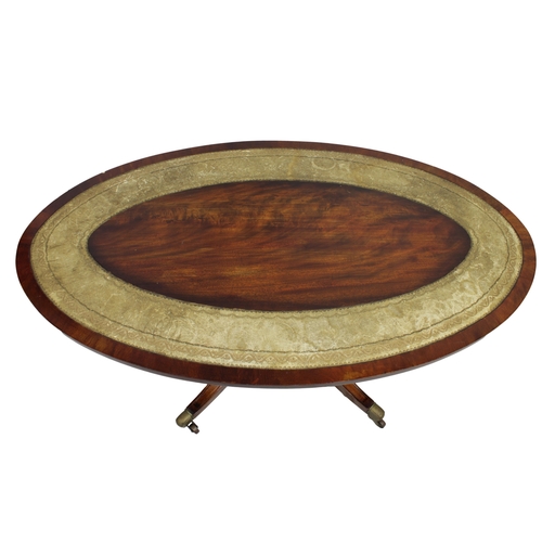 192 - A mahogany oval coffee tableinset tooled leather border, turned support on four sabre legs, brass ca... 