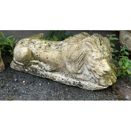 269 - Garden statuary - A pair of heavy marble recumbent lion figuresyellow in colour, raised on rectangul... 