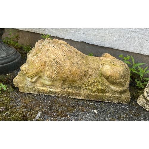 269 - Garden statuary - A pair of heavy marble recumbent lion figuresyellow in colour, raised on rectangul... 