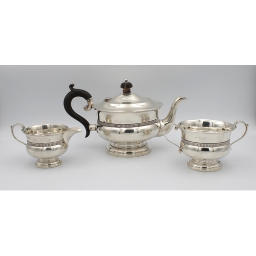 393 - A George V silver tea servicecomprising teapot, milk jug and sugar bowl, of plain waisted form, spre... 