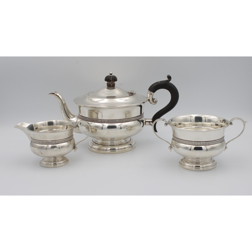 393 - A George V silver tea servicecomprising teapot, milk jug and sugar bowl, of plain waisted form, spre... 