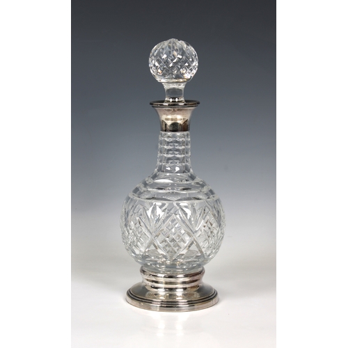 516 - A clear cut glass decanter with a silver top and baseBirmingham, marked 925 and maker's mark "B... 