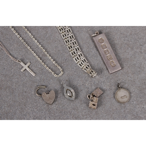 664 - A small collection of silver jewelleryto include ingot; St Christopher; cross; padlock; charms; chai... 