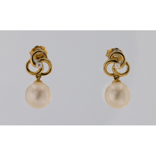 682 - A pair of 9ct yellow gold cultured pearl and diamond earringsthe pin wheel studs each set with a rou... 