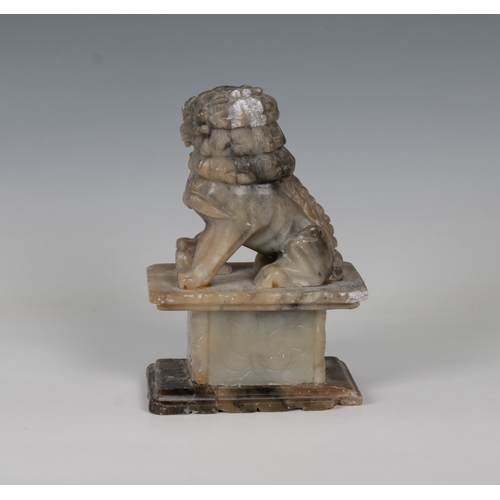 803 - A Chinese carved soapstone Foo Dogon a plinth, 16.5cm. high.