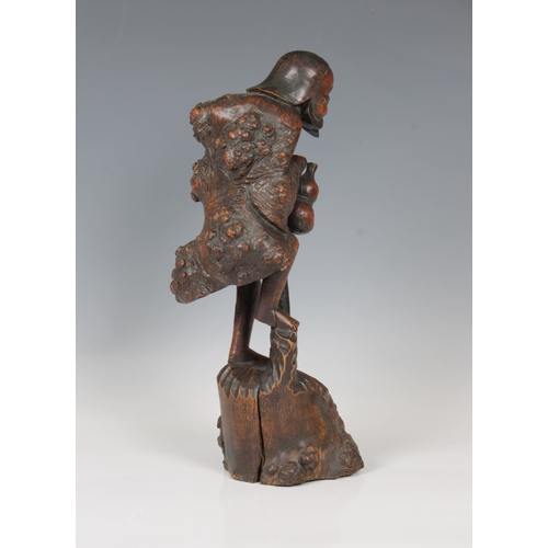 831 - A carved wooden Oriental root figure of an old man with a gourd leaning on a stick33cm. high.