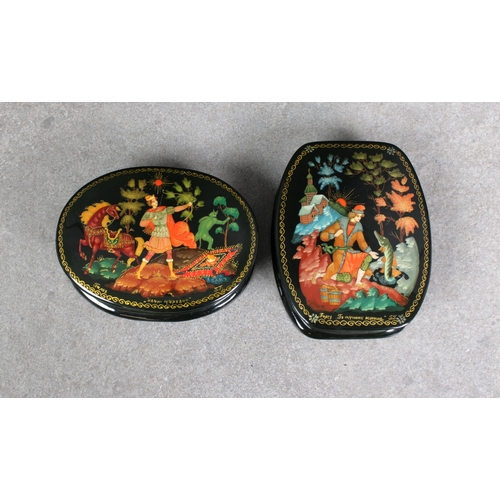 1057 - Two 20th century Russian Lacquered boxesof oval form, the hinged covers, depicting an archer chasing... 