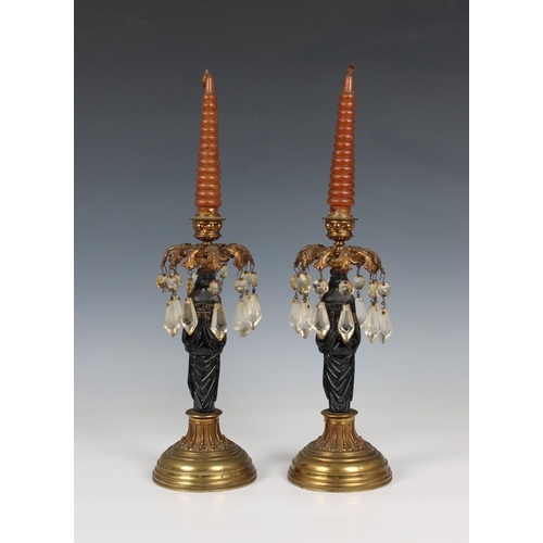 1119 - A pair of figural cast iron and gilt metal Egyptian Revival lustre candlesticksthe painted black fig... 