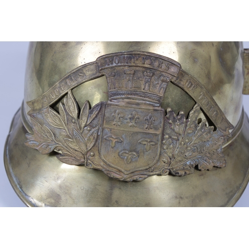 1146 - A French brass fire helmet 'SAPEURS POMPIERS DE TULLE'side plume socket, leather strap, lacks liner.