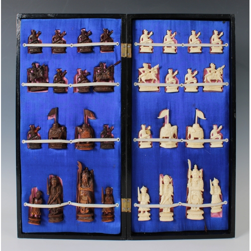 1168 - A 20th century oriental chess setcontained within a black lacqered wooden box doubling as a chess bo... 