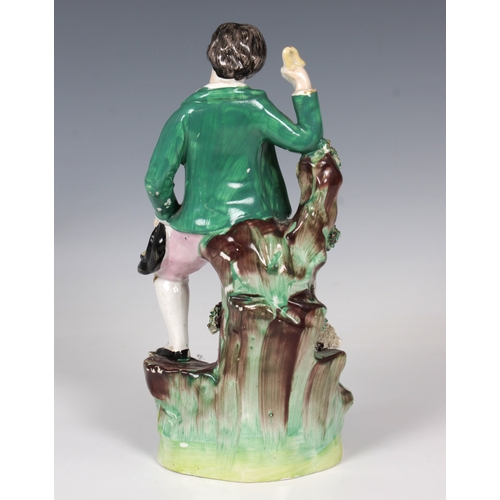 2076 - A 19th century Staffordshire ceramic figure of a young shepherd, in a green jacket with a sheep at h... 