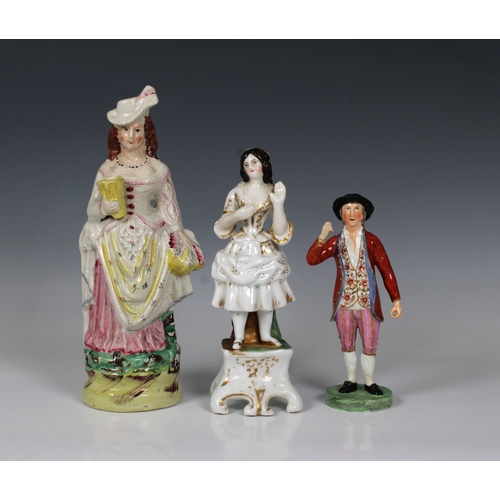 2063 - Three 19th century Staffordshire ceramic figures, of an elegantly dressed young woman 26.5cm. high, ... 