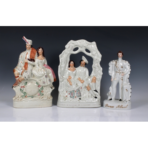 2064 - A 19th century Staffordshire ceramic figure of a Highland couple seated above a clock face, the man ... 