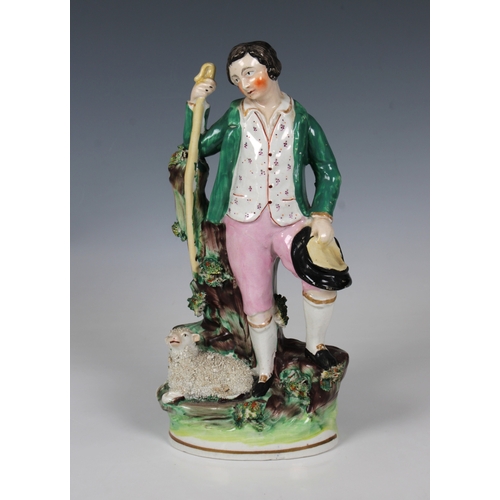 2076 - A 19th century Staffordshire ceramic figure of a young shepherd, in a green jacket with a sheep at h... 