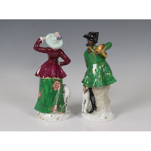 2082 - A pair of 20th century Dresden porcelain figures of a young couple, each with a hunting dog, the man... 