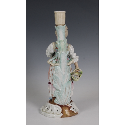 2093 - A Dresden porcelain candlestick in the form of a young woman, underglaze blue cross hatch factory ma... 