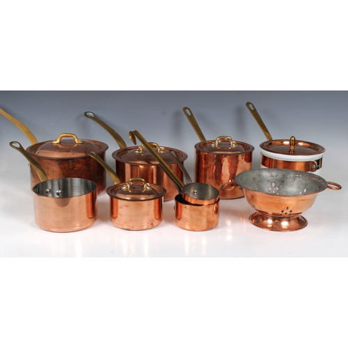 1154 - A collection of French copper and brass tin lined panscomprising four graduated lidded saucepans and... 