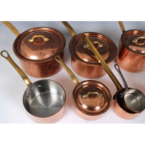 1154 - A collection of French copper and brass tin lined panscomprising four graduated lidded saucepans and... 